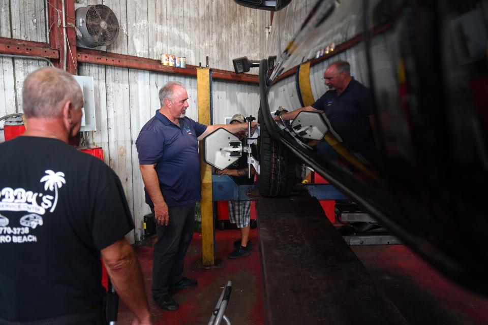 Bobby Ford (center) looks after the work being done on a truck in his shop, Bobby's Auto Service Center, on Wednesday, Sept. 1, 2021, in Vero Beach. Many of the employees at the shop became infected with COVID-19, including Ford's twin brother, Billy, who died Aug. 14 from the illness.