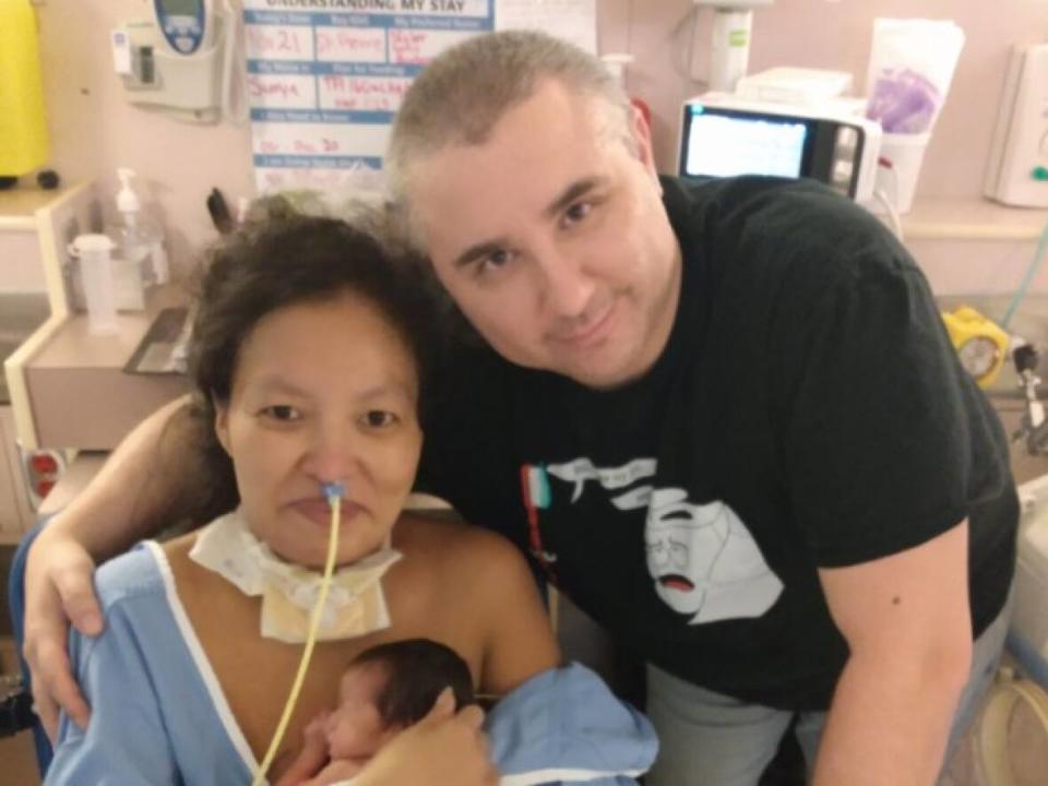 Krystal Binette, left, holds her newborn daughter Skylar while her husband Dwayne Binette visits her in a New Westminster, B.C., hospital. Binette underwent an emergency C-section on Oct. 23 after testing positive for COVID-19 in early October. (Submitted by Dwayne Binette - image credit)