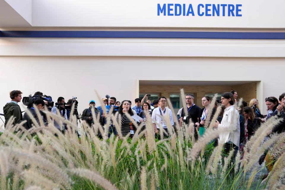 Members of the media wait for analysts to discuss the new text at the Cop28 UN Climate Summit (AP)