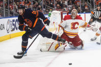 Calgary Flames goalie Jacob Markstrom (25) makes a save on Edmonton Oilers' Zach Hyman (18) during the second period of an NHL hockey game Saturday, Oct. 16, 2021, in Edmonton, Alberta. (Jason Franson/The Canadian Press via AP)