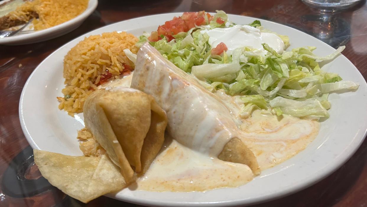 The lobster chimichanga includes a medley of seafood topped with cheese sauce and served with Mexican rice.