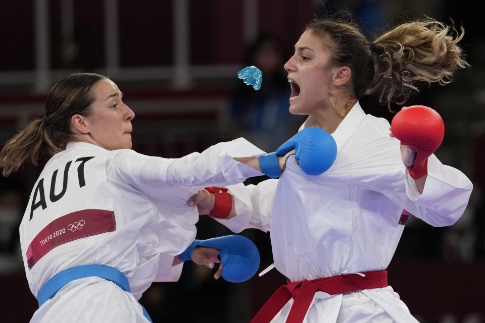 Ivet Goranova of Bulgaria, right, loses her mouth piece near Bettina Plank of Austria during the women's kumite -55kg semifinal bout for Karate at the 2020 Summer Olympics, Thursday, Aug. 5, 2021, in Tokyo, Japan. (AP Photo/Vincent Thian)