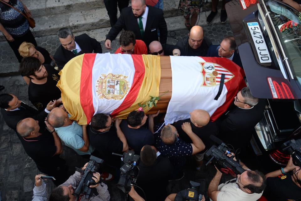 The coffin with the remains of Spanish football player Jose Antonio Reyes, covered with the flags of the village of Utrera and Sevilla FC football team, is carried on shoulders to the Santa Maria de Mesa church in Utrera, during the funeral for the footballer on June 3, 2019. - Former Arsenal, Real Madrid and Spain forward, Jose Antonio Reyes, 35, was killed in a car crash on June 1, 2019. Reyes shot to fame at Sevilla and secured a switch to Arsenal, where he was part of the unbeaten 'Invincibles' 2003-2004 Premier League winners, before spells at Real and Atletico Madrid. (Photo by CRISTINA QUICLER / AFP)        (Photo credit should read CRISTINA QUICLER/AFP/Getty Images)