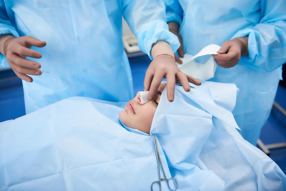 Two plastic surgeons preparing special bandages for female nose after surgery