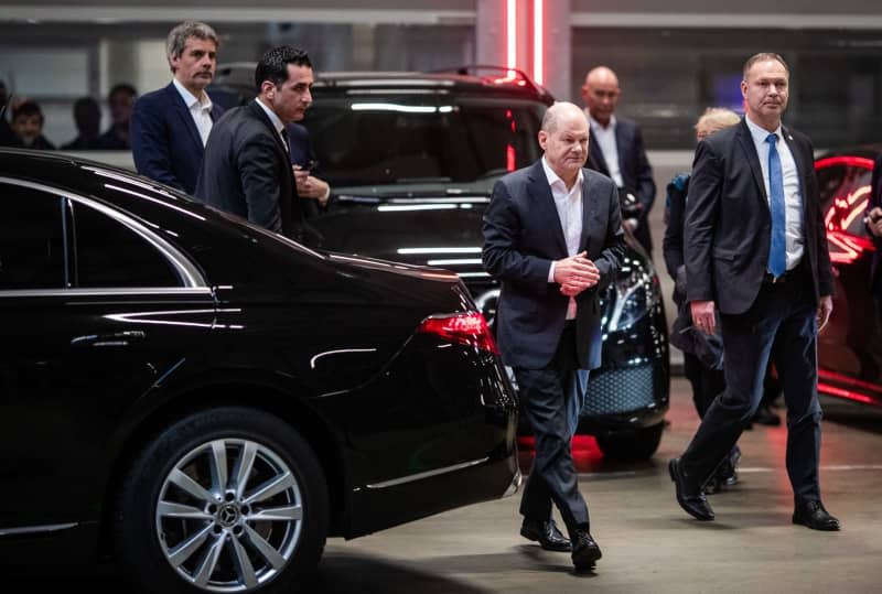 German Chancellor Olaf Scholz (C) arrives at the Mercedes-Benz plant in Sindelfingen as part of his visit to Baden-Wuerttemberg, accompanied by bodyguards. Christoph Schmidt/dpa