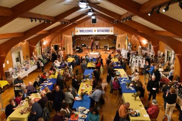 A bird's-eye view of the crowd at the 2022 Ukrainian Festival, enjoying authentic dishes at tables adorned with the colors of the Ukrainian flag.