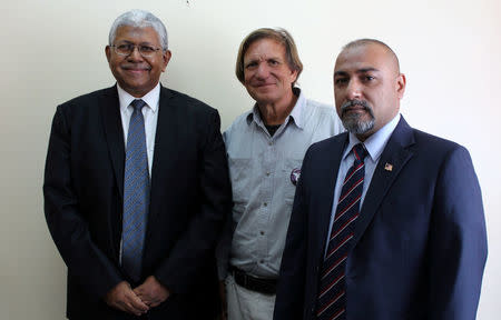 Blaine Gibson (C), an American lawyer turned self-funded sleuth, Aslam Basha Khan (L), an investigator with the official Malaysian inquiry into the plane's disappearance and Zahid Raza (R), Malaysian Consul to Madagascar, pose for a photograph after looking at the debris suspected to be from a Malaysia Airlines Flight MH370, carrying 239 passengers and crew, that went missing more than two years ago at the ministry of transport in Antananarivo, Madagascar December 5, 2016, ahead of a search of the country's beaches for debris from the missing plane. REUTERS/Aislinn Laing