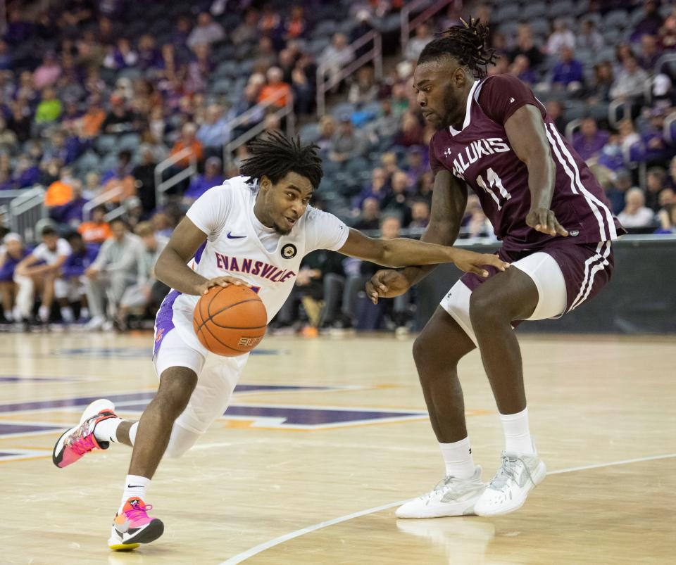 Evansville's Shamar Givance (5), left, drives to the basket as Southern Illinois' JD Muila (11) defends during the basketball game between the University of Evansville Purple Aces and the Southern Illinois Salukis in Evansville, Ind., Wednesday evening, Dec. 1, 2021.