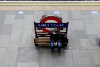 A commuter waits on the platform at Earls Court tube station at morning rush hour