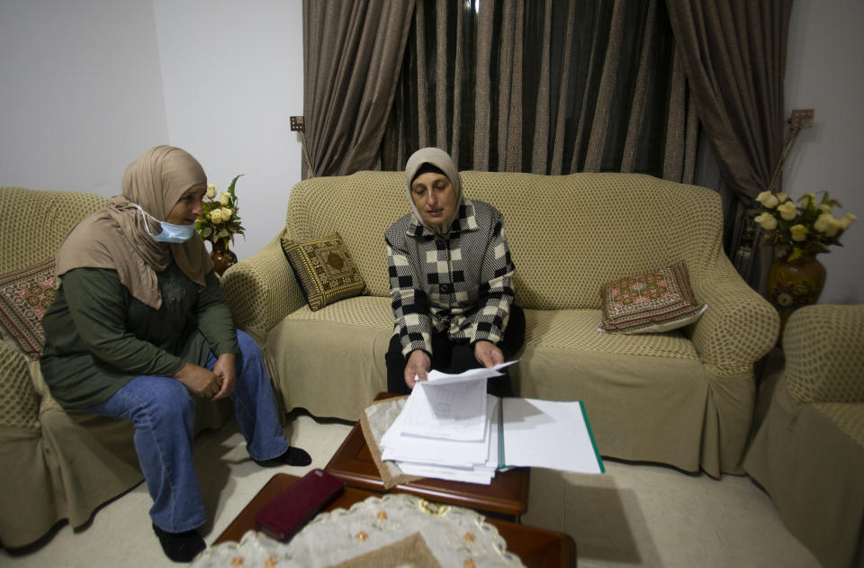 Palestinian sisters Kainat and Karema Quraan show documents of land ownership of land on which some of the Psagot vineyards and a winery building were established, at their home in the West Bank city of Al-Bireh, Tuesday, Nov. 17, 2020. Secretary of State Mike Pompeo's expected tour of a West Bank Psagot winery this week will be the first time a top U.S. diplomat has visited an Israeli settlement, a parting gift from an administration that has taken unprecedented steps to support Israel's claims to war-won territory. (AP Photo / Majdi Mohammed)