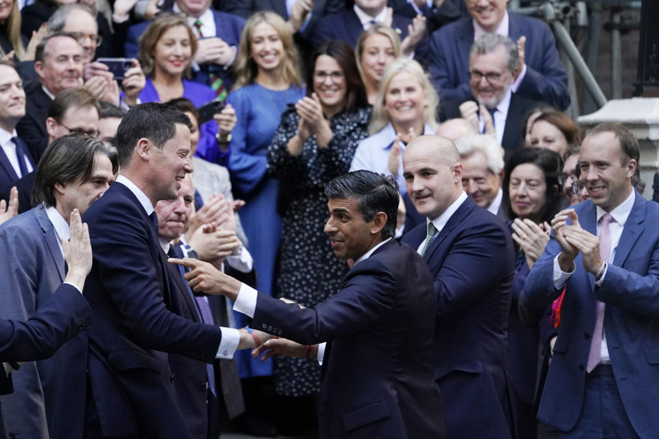 FILE - Rishi Sunak, centre, gestures as conservative MPs greet him after arriving at the Conservative Party leadership contest at the Conservative party Headquarters in London, Oct. 24, 2022. In his first month as Britain's prime minister, Rishi Sunak has stabilized the economy, reassured allies from Washington to Kyiv and even soothed the European Union after years of sparring between Britain and the bloc. But Sunak’s challenges are just beginning. He is facing a stagnating economy, a cost-of-living crisis – and a Conservative Party that is fractious and increasingly unpopular after 12 years in power. (AP Photo/Alberto Pezzali, File)