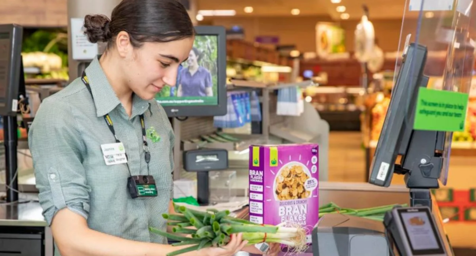 Woolworths worker scanning groceries