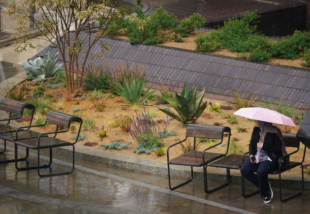 LONDON: A woman sat on a park bench with an umbrella shelters from the rain near Blackfriars in London. (Photo: Yui Mok via PA Wire/PA Images)