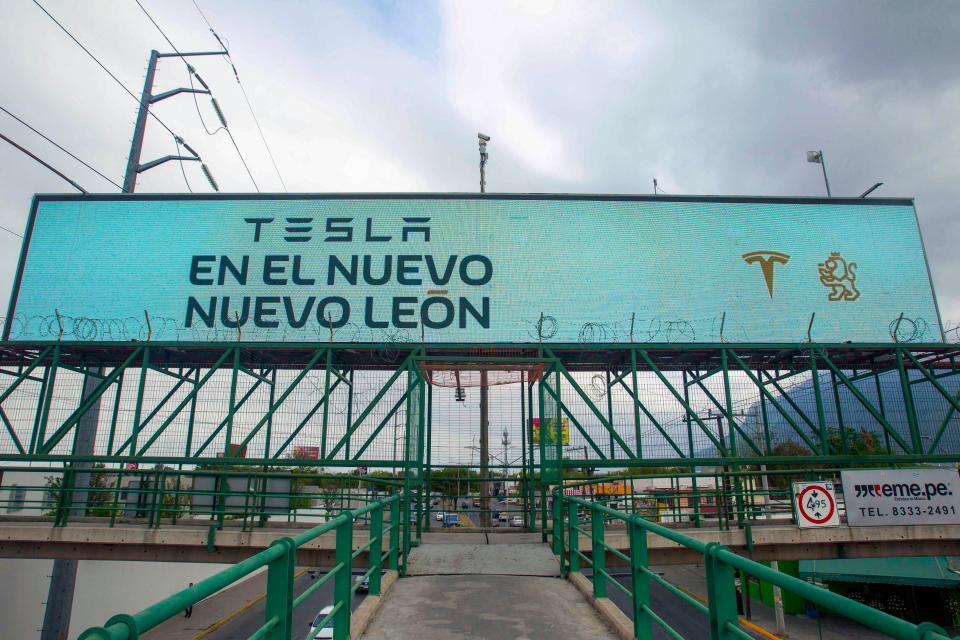 Un cartel anunciando la llegada del fabricante estadounidense de automóviles eléctricos Tesla se ve en Monterrey, estado de Nuevo León, México, el 12 de marzo de 2023. (Foto de JULIO CESAR AGUILAR/AFP via Getty Images)