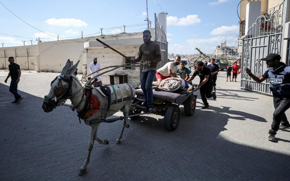 Injured Palestinians are brought to al-Ahli Baptist Hospital after an Israeli attack on az-Zahra school in Gaza City