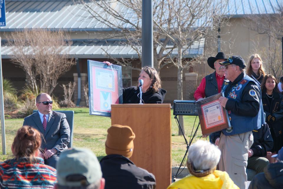 Ameka Mobley of the Ussery-Roan Veterans Home accepts a plaque for the facility's namesakes at the opening ceremony for the Vietnam Traveling Memorial Wall Wednesday at the Ussery-Roan Texas State Veterans Home in Amarillo.