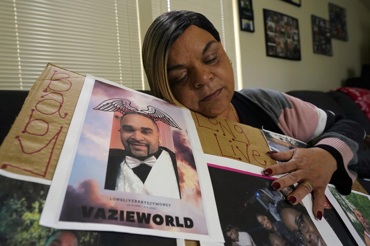 Penelope Scott holds a collection of family photos including one of her son, De'vazia Turner, one of the victims killed in a mass shooting, during an interview with The Associate Press in Elk Grove, Calif., Monday, April 4, 2022. (AP Photo/Rich Pedroncelli)
