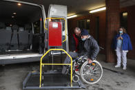 An ambulance operator helps a a patient at the hospital for the homeless in Budapest, Hungary, Wednesday, April 14, 2021. A bitter conflict has emerged between Hungary’s right-wing government and the liberal leadership of the country's capital city over a hospital for the homeless that may soon have to close. The Budapest hospital provides medical and social services and shelter to more than 1,000 people annually. But the Hungarian government has ordered it to vacate the state-owned building it occupies. Budapest's mayor says the eviction will risk the lives of the hospital's homeless patients as Hungary struggles with a deadly COVID-19 surge.. (AP Photo/Laszlo Balogh)