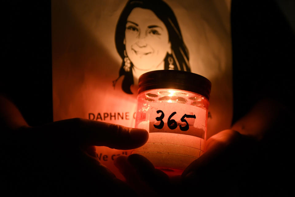 People take part in a vigil to commemorate slain investigative journalist Daphne Caruana Galizia outside the law courts in Valletta, Malta, Tuesday, Oct. 16, 2018. Caruana Galizia, who had probed money-laundering and corruption in the Mediterranean island nation, was killed when a bomb destroyed her car on Oct. 16, 2017. She was 53. (AP Photo/Jonathan Borg)