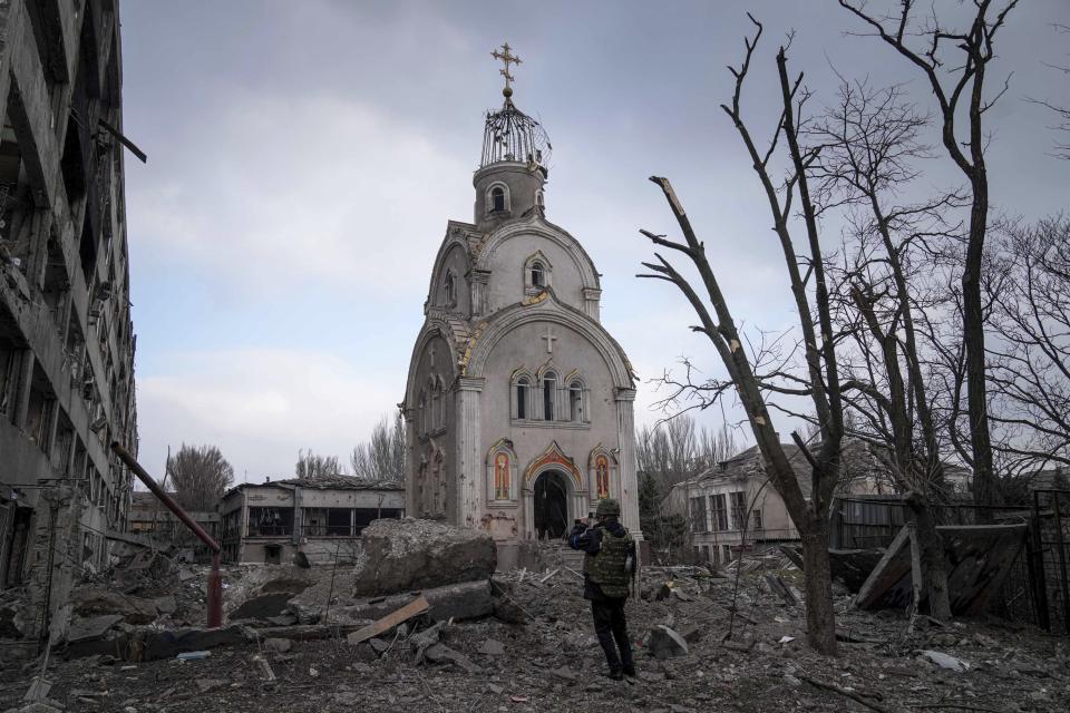 A Ukrainian serviceman takes a photograph of a damaged church after shelling in a residential district in Mariupol, Ukraine, Thursday, March 10, 2022. (AP Photo/Evgeniy Maloletka)