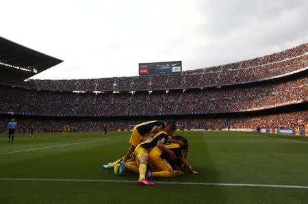 Atletico Madrid's Diego Godin (obscured) is congratulated by teammates after scoring against Barcelona during their Spanish first division soccer match at Camp Nou stadium in Barcelona May 17, 2014. REUTERS/Marcelo del Pozo