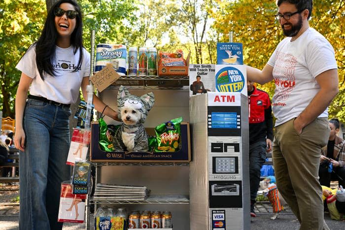 Cat Liu and Kevin Condardo wheel Mimi, a bichon dog, dressed as the bodega cat