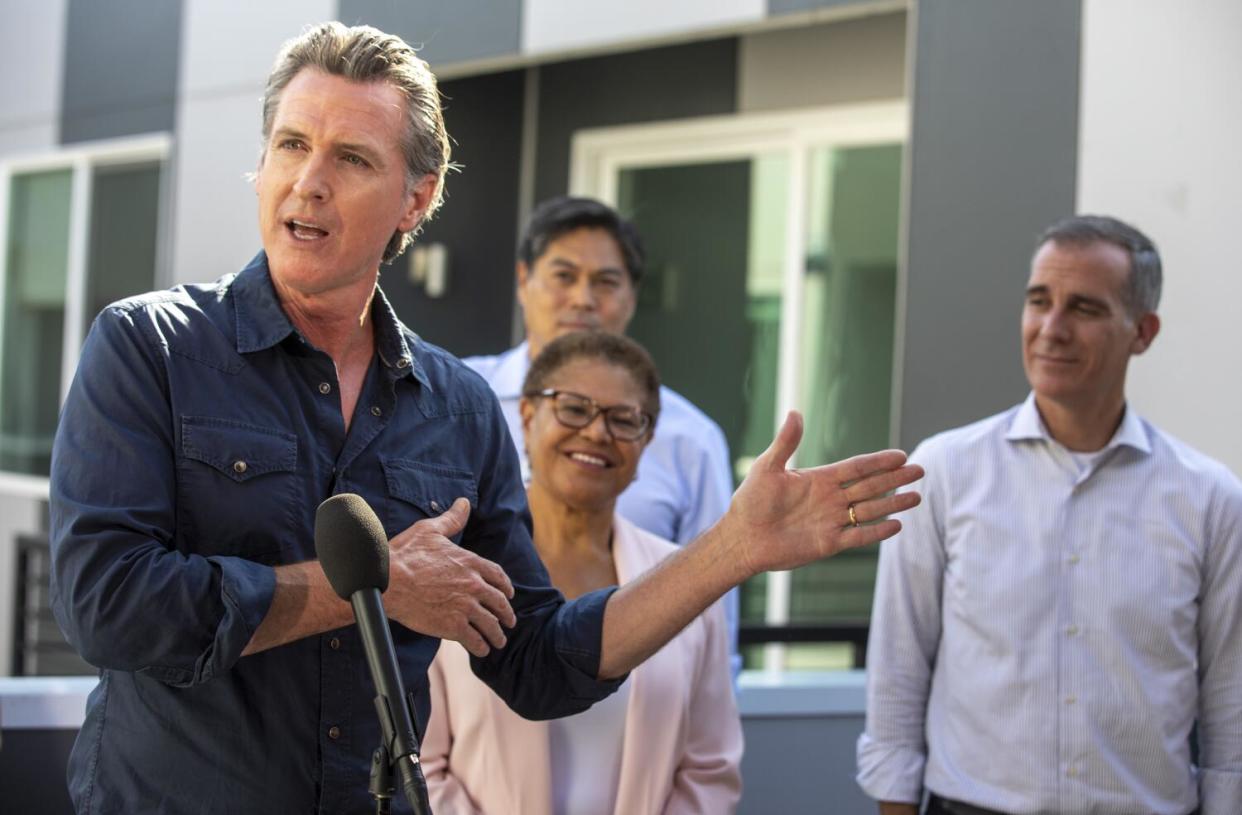 Gov. Gavin Newsom speaks at a news conference with Karen Bass and others.