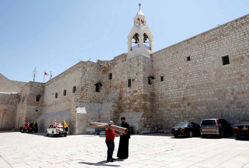 Priests wait for the arrival of the Holy Fire without a crowd due to the coronavirus disease restrictions in Bethlehem