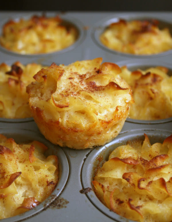 A muffin tin filled with individual noodle kugel muffins.