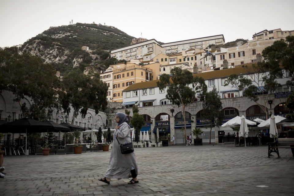 A woman walks on Casemates Square during general elections in Gibraltar, Thursday Oct. 17, 2019. An election for Gibraltar's 17-seat parliament is taking place Thursday under a cloud of uncertainty about what Brexit will bring for this British territory on Spain's southern tip. (AP Photo/Javier Fergo)