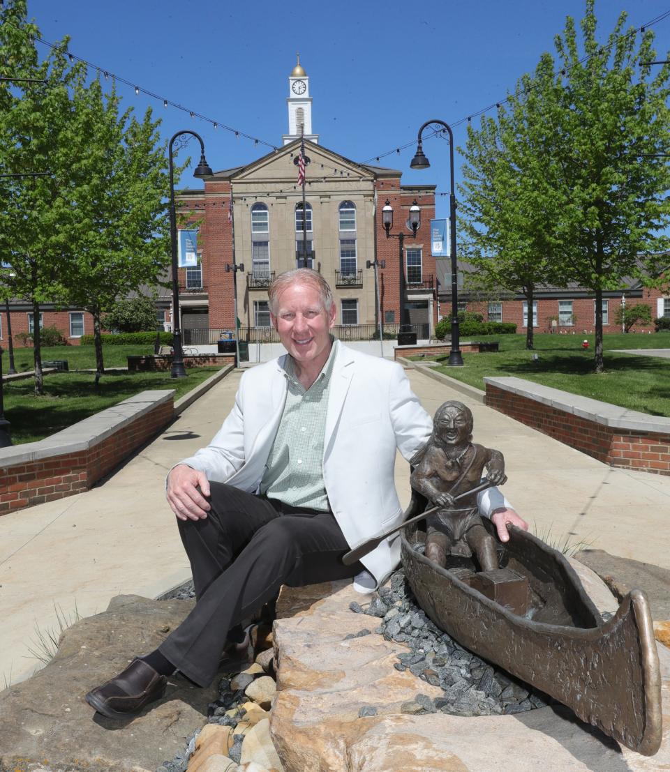 Cuyahoga Falls Mayor Don Walters sits near the "River Trade" sculpture outside the city's municipal offices May 2. The eventual removal of Gorge Dam will result in "first-class" whitewater rapids along the Cuyahoga River, Walters said.