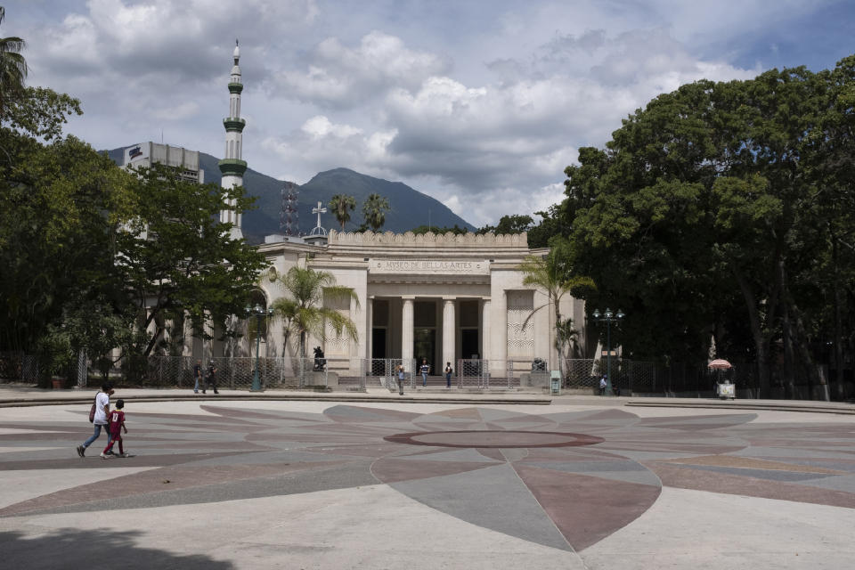 In this Sept. 17, 2019, photo, people walk in front of the Museum of Fine Arts of Caracas, Venezuela. Only about a third of the 18 galleries are open to the public; the rest have been closed for months due to renovations, although there’s no sign any are taking place. (AP Photo/Andrea Hernandez Briceño)