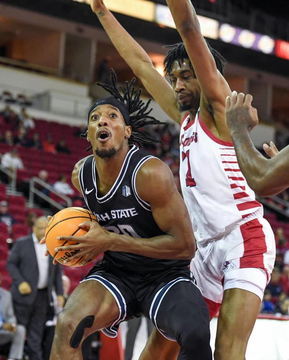 Utah State’s Dan Akin, left, looks to go to the hoop against Fresno State’s Isaih Moore during the first half of their game at the Save Mart Center in Fresno on Saturday, Jan. 28, 2023.