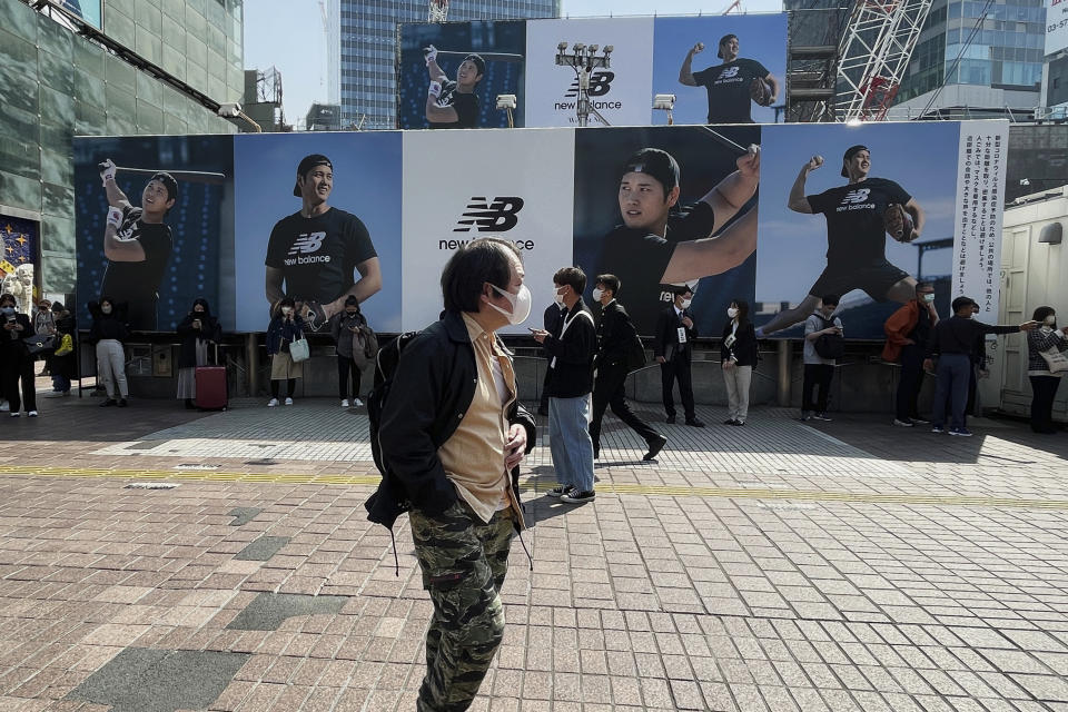 A man walks past a billboard showing pictures of baseball player Shohei Ohtani installed near a train station in the famed Shibuya shopping district in Tokyo on Thursday, March 9, 2023. Japanese baseball player Shohei Ohtani is arguably the game's best player. But he's more than just a baseball player. He's an antidote for many in his native country. (AP Photo/Haruka Nuga)