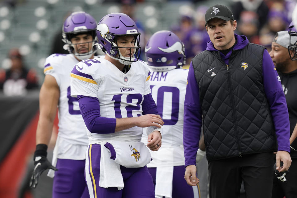 Minnesota Vikings head coach Kevin O'Connell, right, talks to quarterback Nick Mullens (12) before an NFL football game against the Cincinnati Bengals, Saturday, Dec. 16, 2023, in Cincinnati. (AP Photo/Carolyn Kaster)