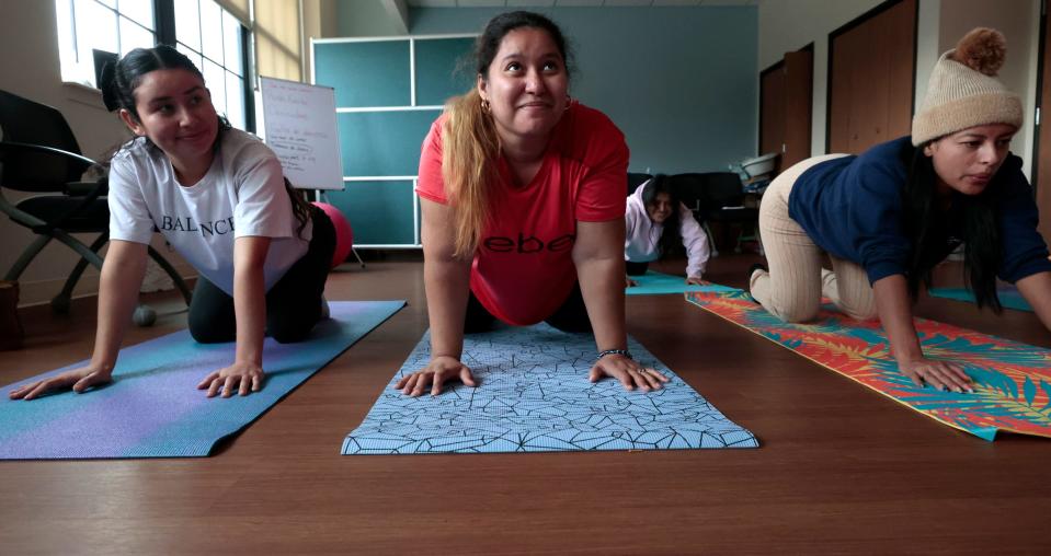 (De izq.) Keydell Fajrdo, de 25 años, Mercedes Cano, de 32 años, y Margarita Moreno, de 30, todas en su segundo trimestre, escuchan a la enfermera practicante Rachel Campbell que las guía a través de ejercicios de yoga en el programa Centering Pregnancy de Covenant Community Care en Detroit el 11 de octubre de 2023. Centering Pregnancy ofrece atención prenatal privada y aprendizaje grupal sobre la importancia de la relajación durante el embarazo y rutinas de ejercicios de yoga prenatal que se pueden realizar en casa, entre otras cosas.