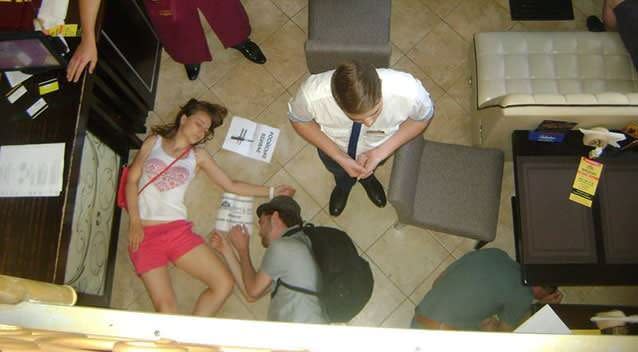 A woman and a man lie down whilst restaurant staff look bemused: Photo Facebook