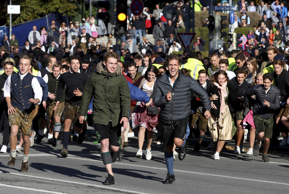 People run to enter the 186th 'Oktoberfest' beer festival in Munich, Germany, Saturday, Sept. 21, 2019. (AP Photo/Matthias Schrader)