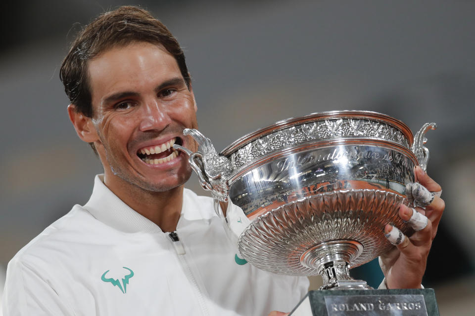 FILE - Spain's Rafael Nadal bites the trophy as he celebrates winning the final match of the French Open tennis tournament against Serbia's Novak Djokovic at Roland Garros stadium in Paris, France, Sunday, Oct. 11, 2020. (AP Photo/Michel Euler, File)