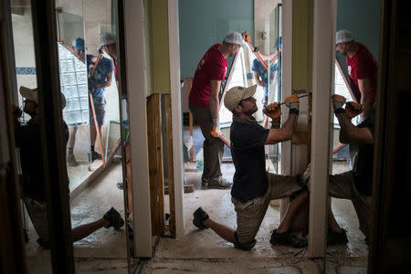 FILE PHOTO: Ben Hyman and other samaritans help clear debris from the house of a neighbor which was left flooded from Tropical Storm Harvey in Houston, Texas, U.S. September 3, 2017. REUTERS/Adrees Latif/File Photo