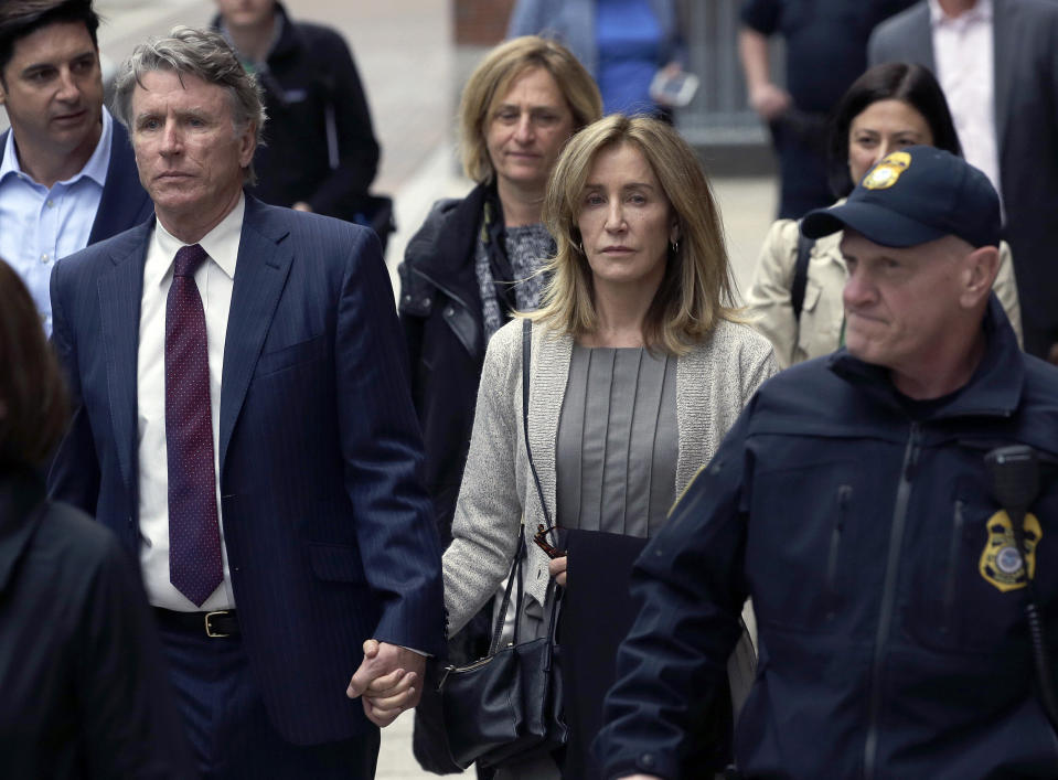 Felicity Huffman, center, leaves federal court with her brother Moore Huffman Jr., left, on May 13, 2019, in Boston. (Photo: AP Photo/Steven Senne)