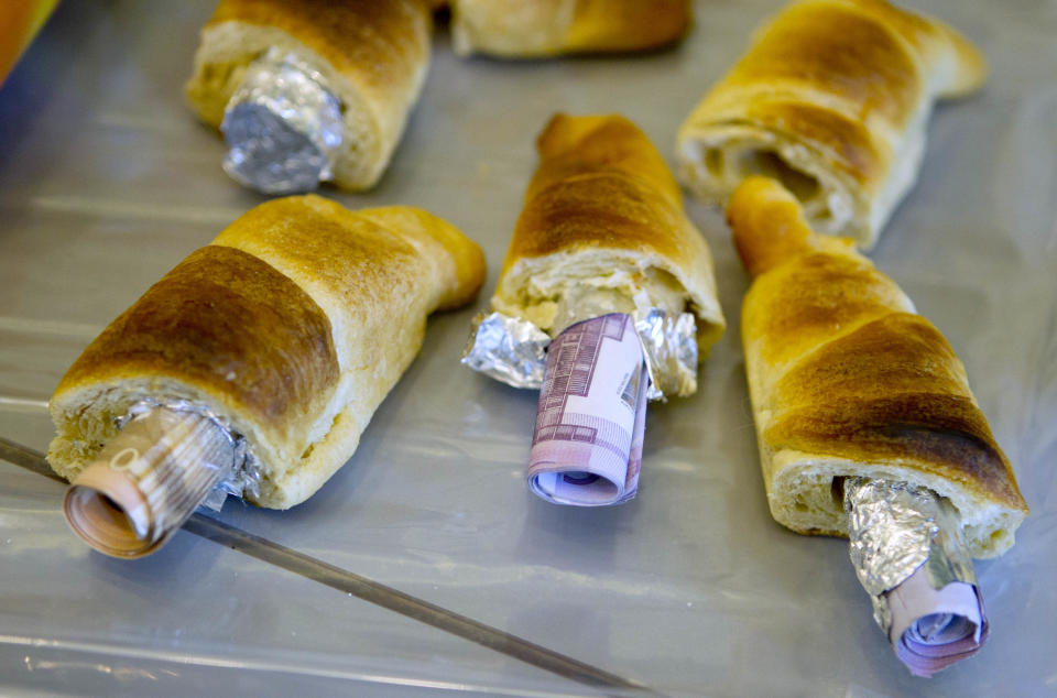 Money concealed in pastries that the German customs agency Zoll seized during an anti-money laundering operation, is displayed before the agency's annual statistics news conference at the finance ministry in Berlin March 16, 2012. REUTERS/Thomas Peter