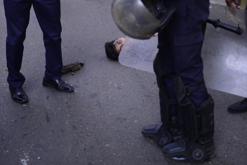 A protestor lies ob the ground after a clash with polce during a protest over an alleged insult to Islam, outside the country’ main Baitul Mukarram Mosque in Dhaka, Bangladesh, Friday, Oct. 15, 2021. Friday’s chaos in Dhaka followed reported incidents of vandalism of Hindu temples in parts of the Muslim-majority Bangladesh after photographs of a copy of the Holy book Quran at the feet of of a Hindu Goddess went viral on social media in a temple at Cumilla district in eastern Bangladesh. (AP Photo/Mahmud Hossain Opu, File)