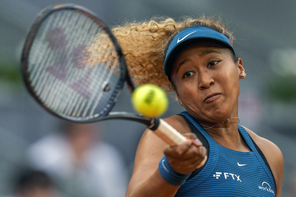 FILE - Naomi Osaka, of Japan, returns the ball against Sara Sorribes Tormo, of Spain, during their match at the Mutua Madrid Open tennis tournament in Madrid, Spain, Sunday, May 1, 2022. The bankruptcy of FTX and the arrest of its founder and former CEO are raising new questions about the role celebrity athletes such as Tom Brady, Steph Curry, Osaka and others played in lending legitimacy to the largely unregulated landscape of crypto, while also reframing the conversation about just how costly blind loyalty to favorite players or teams can be for the average fan. (AP Photo/Manu Fernandez, File)