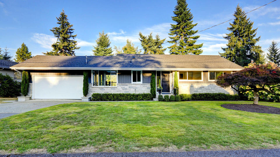 One story house with stone wall trim.