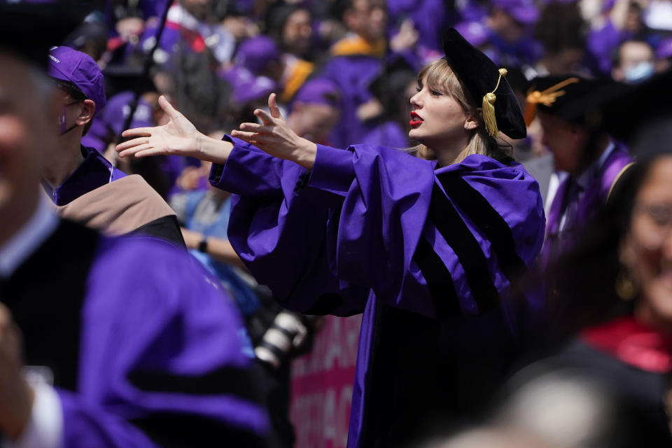 Taylor Swift, center, blows kisses to graduates as she participates in a graduation ceremony for New York University at Yankee Stadium in New York, Wednesday, May 18, 2022. (AP Photo/Seth Wenig)