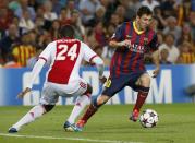 Barcelona's Lionel Messi (R) evades Ajax's Stefano Denswil (L) before scoring his second goal during their Champions League soccer match at Camp Nou stadium in Barcelona September 18, 2013. REUTERS/Gustau Nacarino (SPAIN - Tags: SPORT SOCCER)