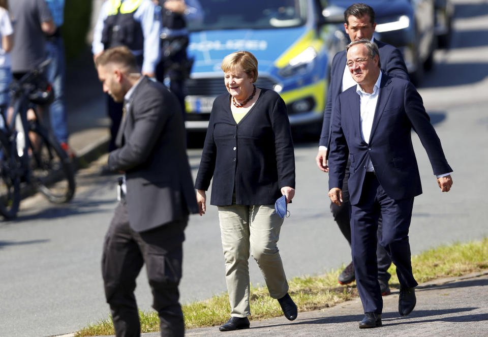 German Chancellor Angela Merkel and North Rhine-Westphalia's State Premier, chairman of the Christian Democratic Union party and candidate for Chancellery Armin Laschet, right, visit the fire station in Schalksmuehle, Germany, Sunday Sept. 5, 2021. (Thilo Schmuelgen/Pool via AP)