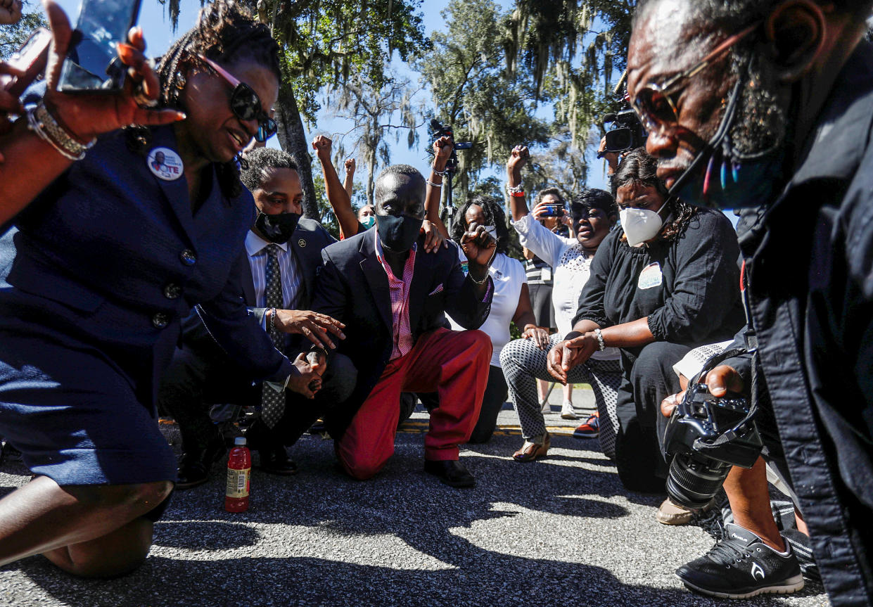 People pray as they visit Satilla Shores neighborhood, where Ahmaud Arbery was killed, in Brunswick, Ga., on Oct. 19, 2021. (Octavio Jones / Reuters)