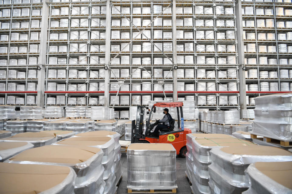 In this photo released by China's Xinhua News Agency, a worker transports products at a fiberglass workshop in a glass products company in Shahe in northern China's Hebei Province, Friday, Jan. 6, 2023. Forecasters say the abrupt decision by President Xi Jinping's government to end controls that shut down factories and kept millions of people at home will move up the timeline for economic recovery, but might disrupt activity this year as businesses scramble to adapt. (Mu Yu/Xinhua via AP)